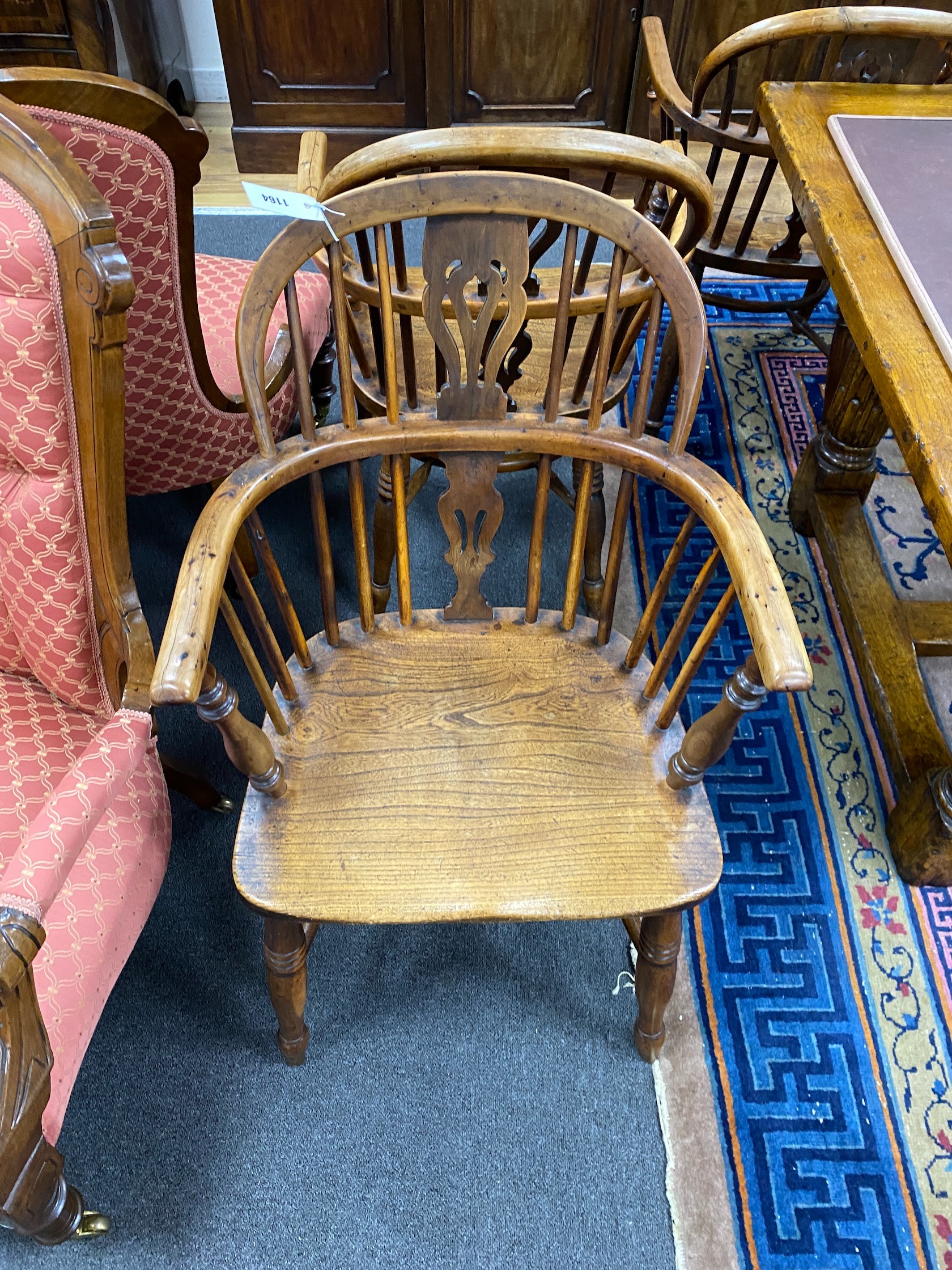 A pair of mid 19th century yew and elm Windsor elbow chairs, with crinoline stretchers, width 55cm, depth 46cm, height 90cm